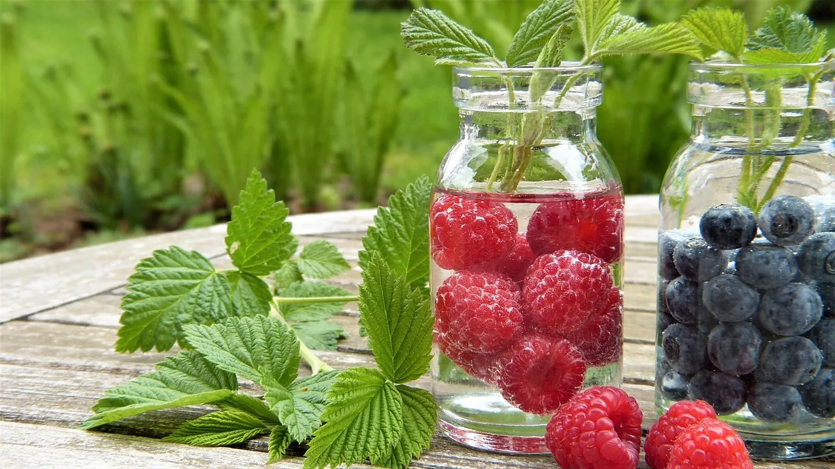 Wasser mit Früchten in Gläsern auf einem Gartentisch