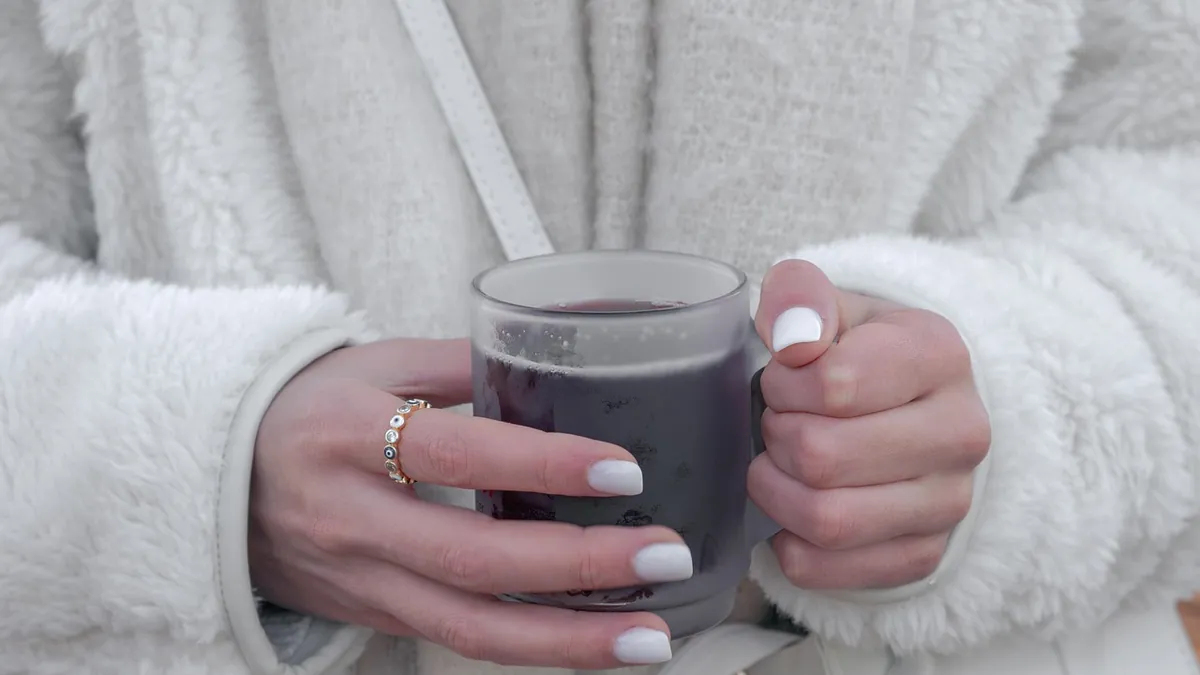Hände halten eine Tasse Glühwein