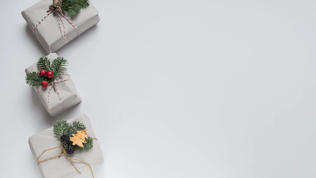 Drei in Packpapier verpackte Geschenke mit Tannenzweigen